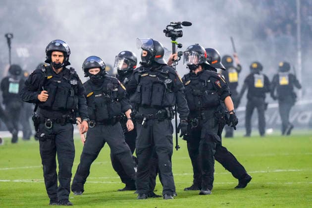 Polizisten sichern das Spielfeld nach Pyroattacken von den Rängen, Erhöhtes Polizeiaufkommen bei der Partie, Polizisten im Stadion, Polizeipräsenz, Polizeischutz, Polizei im Einsatz, Sicherheit, Stadionsicherheit, Symbolfoto, Symbolbild, Symbol, Risikospiel, Hochsicherheitsspiel, Fußballspiel mit einem erhöhten Sicherheitsrisiko, das Spiel wurde im Vorfeld als Hochrisikospiel eingestuft, 21.08.2026, Mannheim (Deutschland), Fussball, DFB-Pokal, 1. Runde, SV Waldhof Mannheim - 1. FC Kaiserslautern, DFB DFL REGULATIONS PROHIBIT ANY USE OF PHOTOGRAPHS AS IMAGE SEQUENCES AND OR QUASI-VIDEO. *** Police officers secure the field after pyrotechnic attacks from the stands; increased police presence at the game; police officers in the stadium; police presence, police protection, police in action, security, stadium security, symbolic photo, symbolic image, symbol, high-risk match, high-security match, soccer match with an increased security risk, the match was classified as a high-risk match in advance, August 21, 2026, Mannheim, Germany, soccer, DFB Cup, 1st round, SV Waldhof Mannheim vs. 1. FC Kaiserslautern, DFB and DFL regulations prohibit any use of photographs as image sequences and or quasi-video xozx