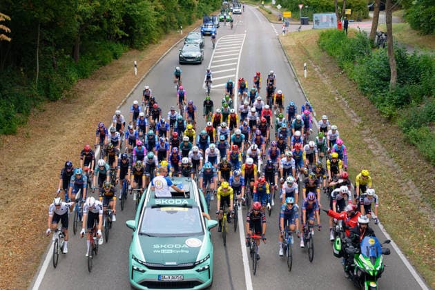 Das Peloton verlässt die Stadt Schwäbisch Hall mit neutralisiertem Start hinter dem Fahrzeug des Rennleiters Fabian Wegmann und de Motorrad der Regulatorin. *** The peloton leaves the town of Schwäbisch Hall with a neutralized start, following behind race director Fabian Wegmann s car and the regulator s motorcycle