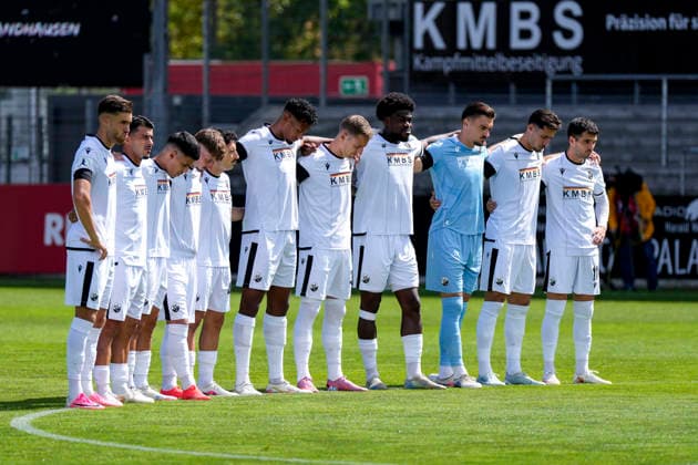 Spieler vom SV Sandhausen bei einer Schweigeminute für den verstorbenen Ehrenpräsidenten Erich Balles (Ehrenpräsident, SVS), vor Spielbeginn, Schweigen, Trauer, Gedenken, Gedenkminute, im Andenken, Anteilnahme, Sprachlosigkeit, Aktion, Action, 22.08.2026, Sandhausen (Deutschland), Fussball, Regionalliga Südwest, SV Sandhausen - FC 08 Homburg *** SV Sandhausen players observing a moment of silence for the late honorary president Erich Balles, SVS, before the start of the game; silence, mourning, remembrance, moment of silence, in memory of, sympathy, speechlessness, event, action, August 22, 2026, Sandhausen, Germany, soccer, Regionalliga Südwest, SV Sandhausen FC 08 Homburg xozx
