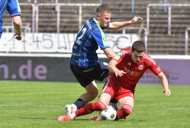 22.08.2026, GER, Fussball, Regionalliga West, Saison 2026 2027, 04. Spieltag, Ohlendorf Stadion im Heidewald, Gütersloh FC Gütersloh - SV Bergisch Gladbach 3 : 1 Justin Lukas (FC Gütersloh, links) gegen Artem Belousov (SV Bergisch Gladbach), Aktion, Duell, Zweikampf *** August 22, 2026, GER, Soccer, Regionalliga West, 2026–2027 Season, Matchday 4, Ohlendorf Stadium in Heidewald, Gütersloh FC vs. SV Bergisch Gladbach 3–1, Justin Lukas (FC Gütersloh, left) vs. Artem Belousov (SV Bergisch Gladbach), action, duel, tackle