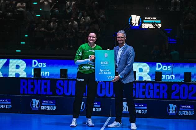 Nicole Roth von der HSG Blomberg-Lippe erhält beim Rexel Super Cup im SAP Garden München die DKB-Auszeichnung als Spielerin des Spiels. Sie hält gemeinsam mit einem Offiziellen die Trophäentafel in die Kamera und lächelt. Nicole Roth als Spielerin des Spiels beim Rexel Super Cup ausgezeichnet *** Nicole Roth of HSG Blomberg Lippe receives the DKB Player of the Game award at the Rexel Super Cup at SAP Garden in Munich. She holds the trophy plaque up to the camera alongside an official and smiles. Nicole Roth is honored as Player of the Game at the Rexel Super Cup. Copyright: xspeedshotx xDorianfrickx