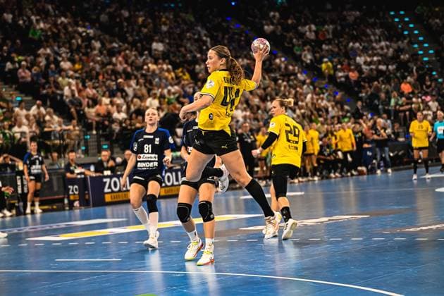 Eine Spielerin von Borussia Dortmund holt mit dem Ball in der erhobenen Hand zum Wurf aus, während eine Gegenspielerin der HSG Blomberg-Lippe ( 81) im Hintergrund heranläuft. Emma Olsson ( 29; Borussia Dortmund) ist im rechten Bildbereich zu sehen, die vollbesetzte Tribüne des SAP Garden bildet den Hintergrund. Borussia Dortmund Spielerin im Wurfmoment beim Handball-Match im SAP Garden *** A Borussia Dortmund player winds up to shoot with the ball held aloft, while an opposing player from HSG Blomberg Lippe 81 runs toward her in the background. Emma Olsson (No. 29) of Borussia Dortmund is visible on the right side of the frame, with the packed stands of the SAP Garden forming the backdrop. A Borussia Dortmund player in the act of shooting during a handball match at the SAP Garden. Copyright: xspeedshotx xDorianfrickx