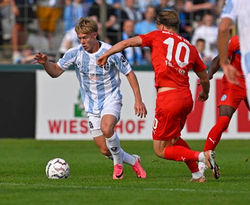 22.08.2026, Fussball DFB-Pokal 2026 27, 1.Runde, TSV 1860 München - Holstein Kiel, im Stadion an der Grünwalderstrasse in München, v.l. Fabio Wagner (TSV 1860 München) gegen Jonas Therkelsen (Holstein Kiel) ***DFL and DFB regulations prohibit any use of photographs as image sequences and or quasi-video.*** *** August 22, 2026, Soccer, 2026–27 DFB Cup, First Round, TSV 1860 Munich vs. Holstein Kiel, at the Stadion an der Grünwalderstrasse in Munich, from left: Fabio Wagner (TSV 1860 Munich) vs. Jonas Therkelsen (Holstein Kiel) ***DFL and DFB regulations prohibit any use of photographs as image sequences and or quasi-video***