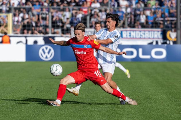 Kampf um den Ball Zweikampf zwischen Jonas Therkelsen (Holstein Kiel, 10) und Tunay Deniz (TSV 1860 Muenchen, 10) GER, TSV 1860 Muenchen vs. Holstein Kiel, Fussball, DFB-Pokal, 1. Runde, Saison 2026 2027, 22.08.2026. (DFL DFB REGULATIONS PROHIBIT ANY USE OF PHOTOGRAPHS as IMAGE SEQUENCES and or QUASI-VIDEO). Foto: HMB Media Heike Feiner *** Battle for the ball: Tackle between Jonas Therkelsen of Holstein Kiel, No. 10, and Tunay Deniz of TSV 1860 Munich, No. 10, GER, TSV 1860 Munich vs. Holstein Kiel, Soccer, DFB Cup, 1st Round, 2026–2027 Season, August 22, 2026. DFL and DFB regulations prohibit any use of photographs as image sequences and or quasi-video. Photo: HMB Media, Heike Feiner Copyright: HMBxMedia HeikexFeiner