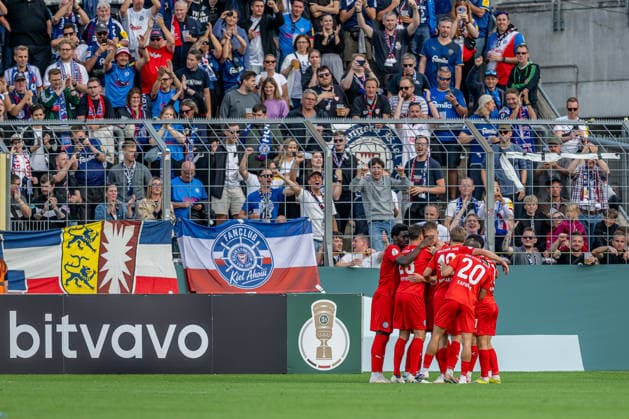 Die Kieler bejubeln vor der eigenen Fankurve mit Phil Harres (Holstein Kiel, 19) dessen Tor zum 0:1 GER, TSV 1860 Muenchen vs. Holstein Kiel, Fussball, DFB-Pokal, 1. Runde, Saison 2026 2027, 22.08.2026. (DFL DFB REGULATIONS PROHIBIT ANY USE OF PHOTOGRAPHS as IMAGE SEQUENCES and or QUASI-VIDEO). Foto: HMB Media Heike Feiner *** Kiel fans cheer in front of their own fan section as Phil Harre of Holstein Kiel, 19, scores the 0-1 goal (GER), TSV 1860 Munich vs. Holstein Kiel, Soccer, DFB Cup, 1st Round, 2026-2027 Season, August 22, 2026 DFL DFB regulations prohibit any use of photographs as image sequences and or quasi-video. Photo: HMB Media, Heike Feiner Copyright: HMBxMedia HeikexFeiner