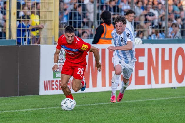 Kampf um den Ball Zweikampf zwischen Lance Fiedler (, TSV 1860 Muenchen, 47) und Adrian Kapralik (Holstein Kiel, 20) GER, TSV 1860 Muenchen vs. Holstein Kiel, Fussball, DFB-Pokal, 1. Runde, Saison 2026 2027, 22.08.2026. (DFL DFB REGULATIONS PROHIBIT ANY USE OF PHOTOGRAPHS as IMAGE SEQUENCES and or QUASI-VIDEO). Foto: HMB Media Heike Feiner *** Battle for the Ball: Tackle between Lance Fiedler (TSV 1860 Munich, 47) and Adrian Kapralik (Holstein Kiel, 20, GER), TSV 1860 Munich vs. Holstein Kiel, Soccer, DFB Cup, 1st Round, 2026–2027 Season, August 22, 2026. DFL and DFB regulations prohibit any use of photographs as image sequences and or quasi-video. Photo: HMB Media, Heike Feiner Copyright: HMBxMedia HeikexFeiner