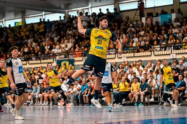 Aron Seesing ( 21; Rhein Neckar Löwen) springt hoch und holt zum Wurf aus, der Ball ist klar über seinem Kopf sichtbar. Im Hintergrund beobachtet Finn Joneleit ( 69; SV Salamander Kornwestheim) die Szene vor voll besetzten Zuschauerrängen in der Sporthalle Ost Kornwestheim. Aron Seesing ( 21; Rhein Neckar Löwen) beim Sprungwurf in Kornwestheim *** Aron Seesing, No. 21 of the Rhein Neckar Löwen, jumps high and winds up to shoot, the ball is clearly visible above his head. In the background, Finn Joneleit (69, SV Salamander Kornwestheim) watches the action from the packed stands at the Sporthalle Ost in Kornwestheim. Aron Seesing (21, Rhein-Neckar Löwen) takes a jump shot in Kornwestheim Copyright: xspeedshotx xDorianfrickx
