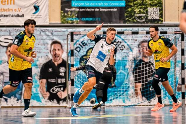 Ein Spieler des SV Salamander Kornwestheim im weißen Trikot mit der Nummer 18 jubelt mit erhobenem Zeigefinger nach einem Torerfolg vor dem Tor. Robert Timmermeister ( 7; Rhein Neckar Löwen) und Aron Seesing ( 21; Rhein Neckar Löwen) laufen im Hintergrund. Jubel nach Tor: Kornwestheim-Spieler ( 18) feiert vor Rhein-Neckar-Löwen-Abwehr *** A player from SV Salamander Kornwestheim in a white jersey with the number 18 celebrates with his index finger raised after scoring a goal in front of the net; Robert Timmermeister (7, Rhein Neckar Löwen) and Aron Seesing (21, Rhein Neckar Löwen) are running in the background; celebration after Kornwestheim’s goalKornwestheim player No. 18 celebrates in front of the Rhein Neckar Löwen defense Copyright: xspeedshotx xDorianfrickx