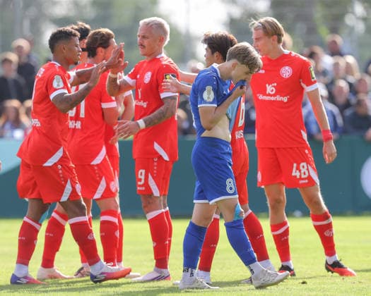 23.08.2026, xtgx, Fussball DFB-Pokal 1. Runde, VfB Krieschow - 1. FSV Mainz 05, v.l. Mainz Jubel, Torjubel, jubelt ueber das Tor, celebrate the goal, celebration, Colin Raak (Krieschow) enttaeuscht, enttäuscht, schaut enttaeuscht, niedergeschlagen, disappointed (DFL DFB REGULATIONS PROHIBIT ANY USE OF PHOTOGRAPHS as IMAGE SEQUENCES and or QUASI-VIDEO) Krieschow *** August 23, 2026, xtgx, Soccer DFB Cup First Round, VfB Krieschow 1 FSV Mainz 05, from left: Mainz celebrating, goal celebration, celebrating the goal, celebration, Colin Raak Krieschow disappointed, looks disappointed, dejected, disappointed DFL DFB REGULATIONS PROHIBIT ANY USE OF PHOTOGRAPHS as IMAGE SEQUENCES and or QUASI-VIDEO Krieschow