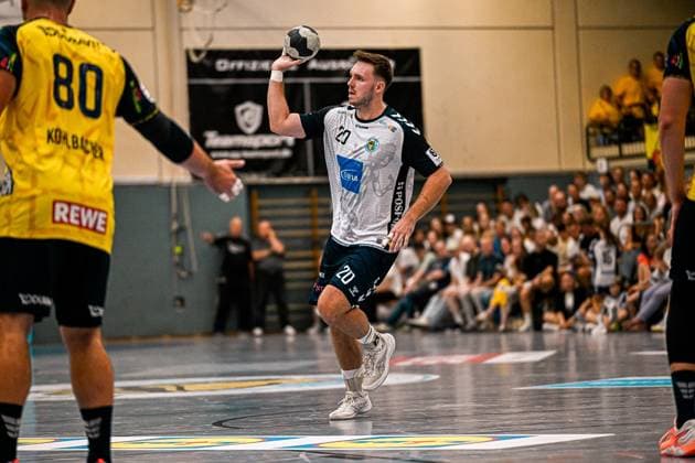 Moritz Lanig ( 20; SV Salamander Kornwestheim) holt mit dem Ball in der erhobenen Hand zum Wurf aus, während Jannik Kohlbacher ( 80; Rhein Neckar Löwen) als Abwehrspieler im Vordergrund steht. Die vollbesetzte Tribüne der Sporthalle Ost Kornwestheim bildet den Hintergrund. Moritz Lanig ( 20; SV Salamander Kornwestheim) beim Wurfansatz *** Moritz Lanig (No. 20, SV Salamander Kornwestheim) winds up to shoot with the ball held aloft, while Jannik Kohlbacher 80 of the Rhein Neckar Löwen stands in the foreground as a defender. The packed stands of the Sporthalle Ost Kornwestheim form the backdrop as Moritz Lanig 20 of SV Salamander Kornwestheim prepares to shoot Copyright: xspeedshotx xDorianfrickx