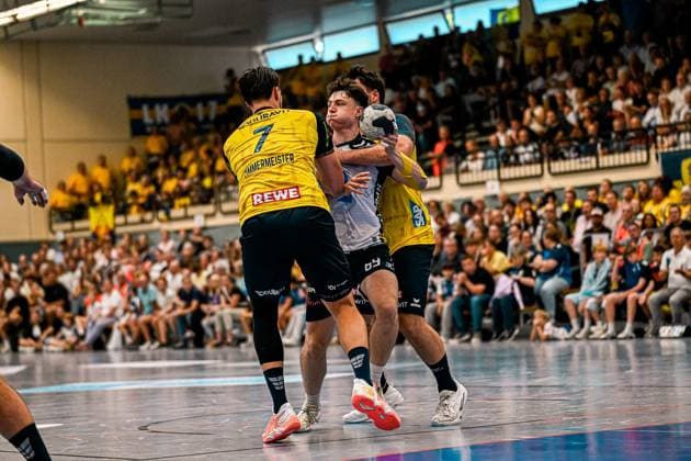 Finn Joneleit ( 69; SV Salamander Kornwestheim) behauptet den Ball unter Druck zweier Spieler der Rhein Neckar Löwen, darunter Robert Timmermeister ( 7). Die vollbesetzte Sporthalle Ost Kornwestheim bildet die Kulisse des intensiven Zweikampfs. Finn Joneleit ( 69; SV Salamander Kornwestheim) im Zweikampf gegen Rhein Neckar Löwen *** Finn Joneleit 69 of SV Salamander Kornwestheim holds onto the ball despite pressure from two players from the Rhein Neckar Löwen, including Robert Timmermeister 7. The packed Sporthalle Ost in Kornwestheim serves as the backdrop for the intense one-on-one battle between Finn Joneleit 69 of SV Salamander Kornwestheim and a player from the Rhein Neckar Löwen. Copyright: xspeedshotx xDorianfrickx