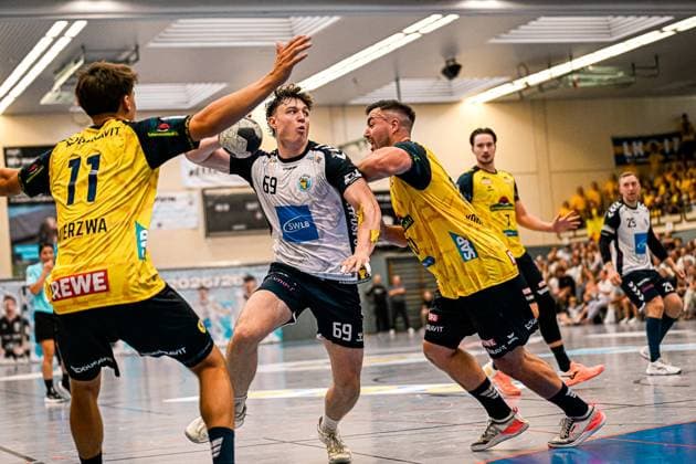 Finn Joneleit ( 69; SV Salamander Kornwestheim) behauptet den Ball unter Druck von Jannik Kohlbacher ( 80; Rhein Neckar Löwen) und Niclas Mierzwa ( 11; Rhein Neckar Löwen) in der Sporthalle Ost Kornwestheim. Der Ball ist im Bild, die Szene zeigt einen intensiven Zweikampf vor voll besetzten Rängen. Finn Joneleit ( 69; SV Salamander Kornwestheim) im Zweikampf gegen Jannik Kohlbacher ( 80; Rhein Neckar Löwen) *** Finn Joneleit 69 of SV Salamander Kornwestheim holds onto the ball under pressure from Jannik Kohlbacher 80 of Rhein Neckar Löwen and Niclas Mierzwa 11 of Rhein Neckar Löwen at the Sporthalle Ost in Kornwestheim. The ball is in the frame, the scene shows an intense battle for the ball in front of a packed crowd. Finn Joneleit (69, SV Salamander Kornwestheim) battles for the ball against Jannik Kohlbacher (80, Rhein Neckar Löwen). Copyright: xspeedshotx xDorianfrickx