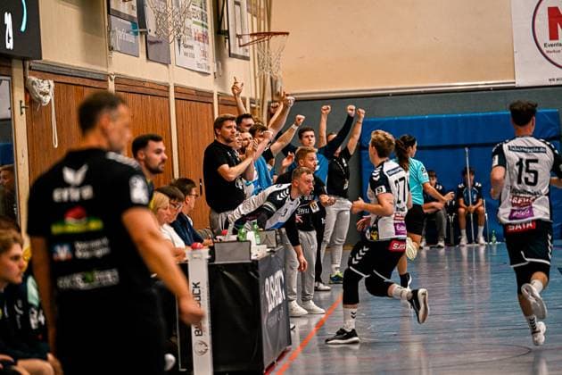 Die Auswechselspieler und Betreuer des SV Salamander Kornwestheim reißen jubelnd die Arme hoch, während Luke Kaysen ( 27; SV Salamander Kornwestheim) und Tim Zeppmeisel ( 15; SV Salamander Kornwestheim) auf dem Spielfeld in Richtung Tor laufen. Die Szene zeigt die emotionale Reaktion der Bank auf einen Torerfolg in der Sporthalle Ost Kornwestheim. SV Salamander Kornwestheim – Jubel auf der Bank nach Torerfolg *** The substitutes and coaches of SV Salamander Kornwestheim raise their arms in celebration, while Luke Kaysen 27 of SV Salamander Kornwestheim and Tim Zeppmeisel 15 of SV Salamander Kornwestheim run toward the goal on the field. The scene shows the emotional reaction of the bench to a goal scored at the Sporthalle Ost in Kornwestheim by SV Salamander Kornwestheim – Cheers on the bench after a goal Copyright: xspeedshotx xDorianfrickx