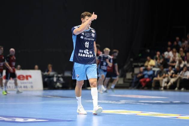 Nicolaj Jørgensen ( 11; HSV Hamburg) steht auf dem Spielfeld der Volkswagen Halle in Braunschweig und streckt den Daumen nach oben, die Hand vor das Gesicht gehoben. Im Hintergrund sind weitere Spieler beider Teams sowie Zuschauer auf den Tribünen zu sehen. Nicolaj Jørgensen ( 11; HSV Hamburg) gibt Signal mit Daumen hoch *** Nicolaj Jørgensen (No. 11, HSV Hamburg) stands on the court at the Volkswagen Halle in Braunschweig and gives a thumbs-up, raising his hand to his face. In the background, other players from both teams and spectators in the stands can be seen. Nicolaj Jørgensen (No. 11, HSV Hamburg) gives a thumbs-up. Copyright: xspeedshotx