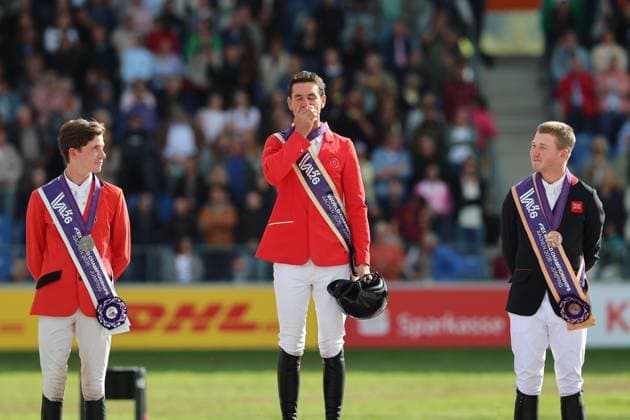 Siegerehrung, Jubel und Kuss der Medaille, 1. Platz, Weltmeister Steve Guerdat (SUI, Schweiz) mit Pferd Dynamix de Belheme, 2. Platz Thibeau Spits (BEL, Belgien, Belgium) mit Pferd Impress-K vaunt Kattenheye Z , Harry Charles (GBR, Vereinigtes Königsreich, Großbritannien) mit Pferd LT Holst Freda, Springen, FEI Jumping World Championship, WM, Weltmeisterschaft , FEI Jumping World Championship, Competition Individual Final, Longines-Prize, Longines-Preis, Finale Einzelwertung, Jumping , AACHEN - FEI World Championships 2026, Weltfest des Pferdesports, Reitsport Weltmeisterschaft 2026, Aachen 2026, Welcome Home 2026, Aachener Soers, 11. bis 23. August 2026, Reitsport, 23.08.2026, Aachen Aachener Soers Deutschland *** Awards ceremony, cheers, and a kiss on the medal, 1st place: World Champion Steve Guerdat (SUI, Switzerland) with Dynamix de Belheme; 2nd place: Thibeau Spits (BEL, Belgium) with Impress K vaunt Kattenheye Z; Harry Charles (GBR, United Kingdom) with LT Holst Freda; Show Jumping, FEI Jumping World Championship, FEI Jumping World Championship, Individual Final, Longines Prize, Longines Prize, Individual Final, Show Jumping, AACHEN FEI World Championships 2026, World Festival of Equestrian Sports, 2026 Equestrian World Championships, Aachen 2026, Welcome Home 2026, Aachener Soers, August 11–23, 2026, Equestrian Sports, August 23, 2026, Aachen Aachener Soers Germany