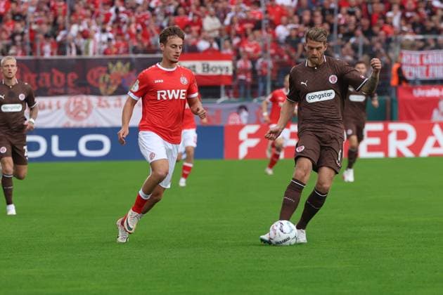 Marcus Mathisen vom FC St. Pauli am Ball, dicht gefolgt von Marvin Obuz ( 10; Rot-Weiss Essen) im Stadion an der Hafenstraße in Essen. Im Hintergrund sind weitere Spieler beider Teams sowie die vollbesetzte Tribüne mit rot-weißen Fanblöcken zu sehen. Marcus Mathisen im Zweikampf mit Marvin Obuz ( 10; Rot-Weiss Essen) *** Marcus Mathisen of FC St. Pauli has the ball, closely followed by Marvin Obuz 10 of Rot-Weiss Essen at the Stadion an der Hafenstraße in Essen. In the background, you can see other players from both teams as well as the packed stands filled with red-and-white fan sections. Marcus Mathisen battles for the ball with Marvin Obuz 10 of Rot-Weiss Essen Copyright: xspeedshotx xTimoxBluhmki-Schmidtx