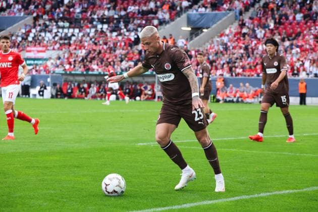 Louis Oppie ( 23; FC St. Pauli) kontrolliert den Ball in der Spielfeldecke, während Semir Telalovi? ( 17; Rot-Weiss Essen) im Hintergrund mitläuft. Im Hintergrund sind weitere Spieler beider Teams sowie die vollbesetzte Tribüne zu sehen. Louis Oppie ( 23; FC St. Pauli) am Ball im Stadion an der Hafenstraße *** Louis Oppie (No. 23) of FC St. Pauli controls the ball in the corner of the field, while Semir Telalovi (No. 17) of Rot-Weiss Essen runs alongside him in the background. In the background, other players from both teams can be seen, as well as the packed stands. Louis Oppie (No. 23) of FC St. Pauli has the ball at the stadium on Hafenstraße. Copyright: xRuhr.Pottraitx