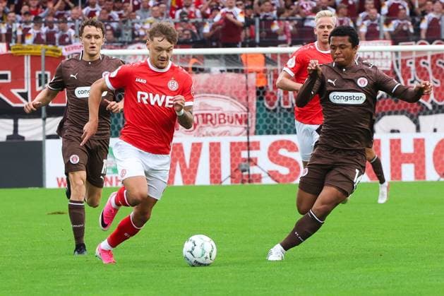 Jannik Hofmann von Rot-Weiss Essen treibt den Ball voran, während Joel Chima Fujita vom FC St. Pauli ihn unter Druck setzt. Im Hintergrund begleiten Martijn Kaars (FC St. Pauli) und Janne Sietan ( 22; Rot-Weiss Essen) die Szene. Jannik Hofmann (Rot-Weiss Essen) im Zweikampf mit Joel Chima Fujita (FC St. Pauli) *** Jannik Hofmann of Rot Weiss Essen drives the ball forward, while Joel Chima Fujita of FC St. Pauli puts pressure on him. In the background, Martijn Kaars of FC St. Pauli and Janne Sietan of Rot Weiss Essen watch the action unfold. Jannik Hofmann of Rot Weiss Essen battles for the ball with Joel Chima Fujita of FC St. Pauli. Copyright: xRuhr.Pottraitx