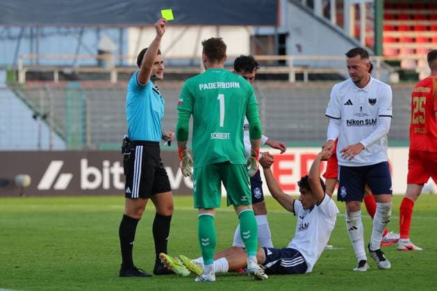 23.08.26, GER, DFB-Pokal, Fussball, 1.Runde, Saison 2026 2027, Dietmar-Scholze-Stadion an der Lohmuehle, 1.FC Phönix Lübeck vs SC Paderborn 07 Gelb die Gelbe Karte Schiedsrichter Felix Prigan zeigt Torwart Markus Schubert (SC Paderborn 07 01) die Gelbe Karte nach Foul an Julius Kliti (1.FC Phoenix Luebeck 07) Foto nordphoto GmbH Tauchnitz Luebeck Dietmar-Scholze-Stadion an der Lohmuehle SH Germany *** August 23, 2026, Germany, DFB Cup, Soccer, First Round, 2026–2027 Season, Dietmar Scholze Stadion an der Lohmuehle, 1 FC Phönix Lübeck vs. SC Paderborn 07 Yellow Card: Referee Felix Prigan shows goalkeeper Markus Schubert (SC Paderborn 07, No. 01) a yellow card after a foul on Julius Kliti (1 FC Phoenix Lübeck 07). Photo: nordphoto GmbH, Tauchnitz, Luebeck, Dietmar Scholze Stadium an der Lohmuehle, SH, Germany Copyright: xnordphotoxGmbHx xTauchnitzx