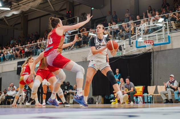 Emily Bessoir ( 22; Deutschland A-Natio DamenBB 2026) hält den Ball in beiden Händen und sucht eine Anspielstation, während eine ungarische Verteidigerin ( 24) mit erhobener Hand Druck macht. Im Hintergrund verfolgen zahlreiche Zuschauer in der Sparkassen-Arena Göttingen das Spielgeschehen. Emily Bessoir ( 22; Deutschland A-Natio DamenBB 2026) im Angriff gegen Ungarn *** Emily Bessoir, 22, Germany A National Women s BB 2026, holds the ball in both hands and looks for a teammate to pass to, while a Hungarian defender (No. 24) applies pressure with her hand raised. In the background, numerous spectators at the Sparkassen Arena in Göttingen watch the action as Emily Bessoir (No. 22, Germany A National Women’s BB 2026) attacks against Hungary. Copyright: xJoelxKruehlerx