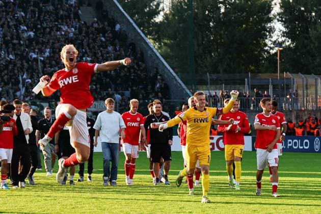 Die Spieler von Rot-Weiss Essen laufen jubelnd über den Rasen des Stadions an der Hafenstraße, ein Feldspieler springt mit geballter Faust in die Luft, Jakob Golz im gelben Torwarttrikot und Marvin Obuz feiern gemeinsam mit dem Team. Im Hintergrund sind zahlreiche Zuschauer auf den Tribünen zu sehen. Jakob Golz und Marvin Obuz feiern Sieg mit Rot-Weiss Essen *** The Rot Weiss Essen players run jubilantly across the field at the stadium on Hafenstraße; one field player jumps into the air with a clenched fist, Jakob Golz in his yellow goalkeeper jersey and Marvin Obuz celebrate together with the team. In the background, numerous spectators can be seen in the stands. Jakob Golz and Marvin Obuz celebrate the victory with Rot Weiss Essen. Copyright: xRuhr.Pottraitx