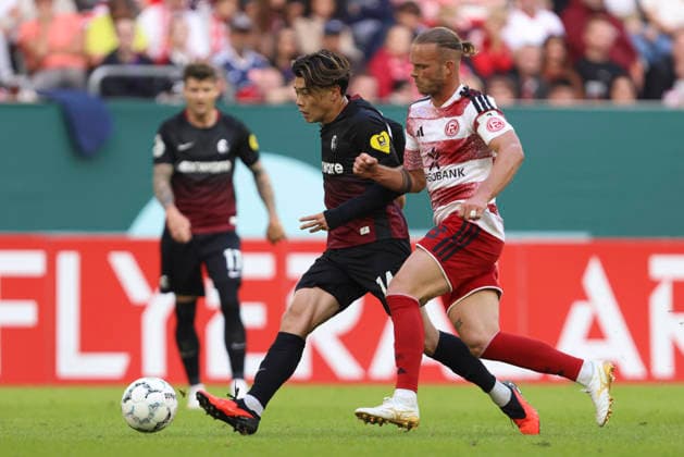 Yuito Suzuki (SC Freiburg) und Jorrit Hendrix (Fortuna Duesseldorf) im Zweikampf waehrend des Spiels der 1. Runde des DFB-Pokal zwischen Fortuna Duesseldorf und SC Freiburg, Merkur Spiel-Arena am 23. August 2026 in Duesseldorf, Deutschland. (Foto von Oliver Kaelke DeFodi Images) +++ Yuito Suzuki (SC Freiburg) und Jorrit Hendrix (Fortuna Duesseldorf) battle for the ball during the 1st round match of the DFB-Pokal between Fortuna Duesseldorf and SC Freiburg at Merkur Spiel-Arena on August 23, 2026 in Dusseldorf, Germany. (Photo by Oliver Kaelke DeFodi Images) DFB DFL REGULATIONS PROHIBIT ANY USE OF PHOTOGRAPHS AS IMAGE SEQUENCES AND OR QUASI-VIDEO. (Photo by Oliver Kaelke DeFodi Images) - *** Yuito Suzuki of SC Freiburg and Jorrit Hendrix of Fortuna Düsseldorf in a tackle during the first-round DFB Cup match between Fortuna Düsseldorf and SC Freiburg at the Merkur Spiel Arena on August 23, 2026, in Düsseldorf, Germany. Photo by Oliver Kaelke, DeFodi Images. Yuito Suzuki of SC Freiburg and Jorrit Hendrix of Fortuna Düsseldorf battle for the ball during the first-round match of the DFB Cup between Fortuna Düsseldorf and SC Freiburg at Merkur Spiel Arena on August 23, 2026 in Düsseldorf, Germany. Photo by Oliver Kaelke, DeFodi Images. DFB and DFL regulations prohibit any use of photographs as image sequences and or quasi-video. Photo by Oliver Kaelke, DeFodi Images.