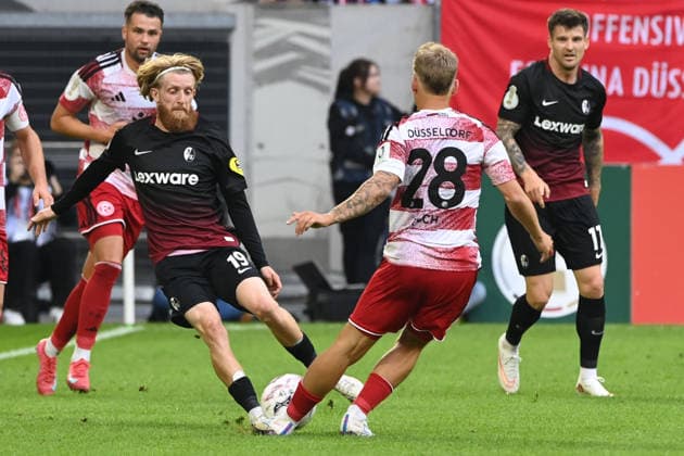 Niklas BESTE (FR) gegen Sascha RISCH (D) Aktion, Zweikampf, Fussball DFB Pokal, 1. Hauptrunde, Fortuna Duesseldorf (D) - SC Freiburg (FR) 1-5 am 23.08.2026 in der Merkur Spiel Arena Duesseldorf Deutschland. DFL DFB regulations prohibit any use of photographs as image sequences and or quasi-video Â *** Niklas BESTE (FR) vs. Sascha RISCH (D) Action, Tackle, Soccer, DFB Cup, 1st Round, Fortuna Düsseldorf vs. SC Freiburg, Friday, August 23, 2026, at the Merkur Spiel Arena in Düsseldorf, Germany. DFL and DFB regulations prohibit any use of photographs as image sequences and or quasi-video.