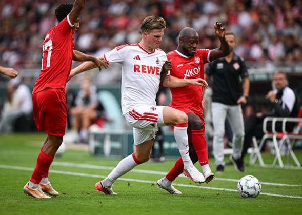 Fussball DFB Pokal 1. Runde Saison 2026 2027 24.08.2026 FC Wuerzburger Kickers - 1. FC Koeln Marius Buelter (Mitte, 1. FC Koeln) gegen David Kinsombi (re, Kickers) und Liam Omore (li, Kickers) *** Soccer, DFB Cup, First Round, 2026–2027 Season, August 24, 2026: FC Würzburger Kickers 1–0 FC Köln. Marius Buelter (center), FC Köln vs. David Kinsombi (right), Kickers, and Liam Omore (left), Kickers
