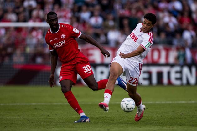 WUERZBURG, GERMANY - AUGUST 24: Tarsis Bonga (Wuerzburger Kickers, 30) and Jahmai Simpson-Pusey (1. FC Koeln, 22) battle for the ball during the 1st round DFB Pokal match between Wuerzburger Kickers vs. 1. FC Koeln at AKON ARENA on August 24, 2026 in Wuerzburg, Germany. DFB REGULATIONS PROHIBIT ANY USE OF PHOTOGRAPHS AS IMAGE SEQUENCES AND OR QUASI-VIDEO. Bavaria Germany Copyright: xSteffiexWunderlx