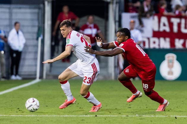 WUERZBURG, GERMANY - AUGUST 24: Paul Okon-Engstler (1. FC Koeln, 23) controls the ball against Franck Evina (Wuerzburger Kickers, 18) during the 1st round DFB Pokal match between Wuerzburger Kickers vs. 1. FC Koeln at AKON ARENA on August 24, 2026 in Wuerzburg, Germany. DFB REGULATIONS PROHIBIT ANY USE OF PHOTOGRAPHS AS IMAGE SEQUENCES AND OR QUASI-VIDEO. Bavaria Germany Copyright: xSteffiexWunderlx