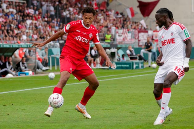 Im Bild: v.li. Liam Omore (FC Wuerzburger Kickers, 17) am Ball gegen Gideon Mensah (1. FC Koeln, 14) 24.08.2026, FC Wuerzburger Kickers - 1. FC Koeln, DFB-Pokal, 1. Runde, Deutschland, Wuerzburg, AKON-Arena, DFL REGULATIONS PROHIBIT ANY USE OF PHOTOGRAPHS AS IMAGE SEQUENCES AND OR QUASI-VIDEO. *** Pictured from left: Liam Omore (FC Würzburger Kickers, 17) with the ball against Gideon Mensah (1. FC Köln, 14) on August 24, 2026, FC Würzburg Kickers vs. 1. FC Köln, DFB Cup, First Round, Germany, Würzburg, AKON Arena, DFL regulations prohibit any use of photographs as image sequences and or quasi-video Copyright: HMBxMedia xJulienxBecker