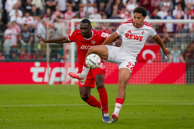 Im Bild: v.li. Tarsis Bonga (FC Wuerzburger Kickers, 30) gegen Jahmai Simpson-Pusey (1. FC Koeln, 22) am Ball 24.08.2026, FC Wuerzburger Kickers - 1. FC Koeln, DFB-Pokal, 1. Runde, Deutschland, Wuerzburg, AKON-Arena, DFL REGULATIONS PROHIBIT ANY USE OF PHOTOGRAPHS AS IMAGE SEQUENCES AND OR QUASI-VIDEO. *** In the photo, from left: Tarsis Bonga (FC Würzburger Kickers, No. 30) and Jahmai Simpson Pusey (FC Köln, No. 22) with the ball on August 24, 2026, FC Würzburg Kickers vs. 1. FC Köln, DFB Cup, First Round, Germany, Würzburg, AKON Arena; DFL regulations prohibit any use of photographs as image sequences and or quasi-video Copyright: HMBxMedia xJulienxBecker
