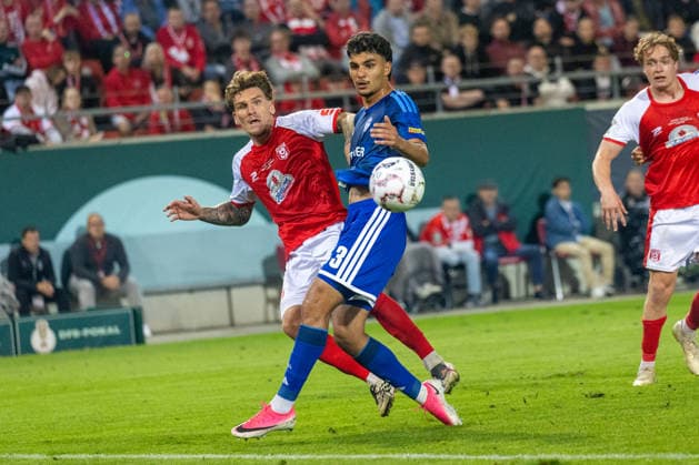 Deutschland: DFB Pokal, Saison 2026 2027, 24.08.2026, 1.Runde , Hallescher FC vs FC Schalke 04 , Leuna-Chemie-Stadion : Ayhan, Mertcan (FC Schalke 04, 43) im Zweikampf gegen Stierlin, Niclas (Hallescher FC, 13) *** Germany DFB Cup, 2026–2027 Season, August 24, 2026, First Round, Hallescher FC vs. FC Schalke 04, Leuna Chemie Stadium: Ayhan, Mertcan (FC Schalke 04, No. 43) in a tackle against Stierlin, Niclas (Hallescher FC, No. 13) Copyright: xMichellexLukax