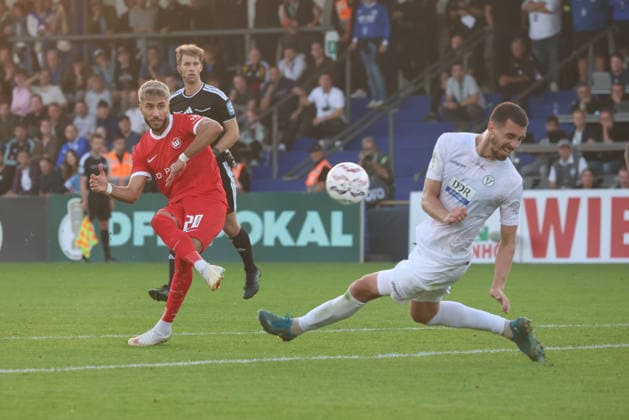 BERLIN, GERMANY - AUGUST 24: Muhammed Damar (Wolfsburg, 20) shoots at the goal against Sven Sonnenberg (VSG Altglienicke, 4), during the DFB Cup DFB Pokal match (Round 1) between DFB-Pokal: VSG Altglienicke - VfL Wolfsburg at Stadion auf dem Wurfplatz (Amateurstadion im Olympiapark) on August 24, 2026 in Berlin, Germany. DFL REGULATIONS PROHIBIT ANY USE OF PHOTOGRAPHS AS IMAGE SEQUENCES AND OR QUASI-VIDEO. Berlin Germany Copyright: xO.Frankex