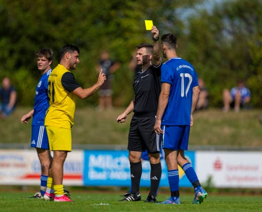 23.08.2026, Fussball Bezirksliga Schwaben Süd 2026 27, 6.Spieltag, FC Bad Wörishofen - FC Thalhofen, im Stadion Bad Wörishofen. 2.v.re: Schiedsrichter Patrick Höpfler zeigt Ilir Hajra (BAd Wörishofen) die gelbe Karte. li: Kevin Volland (Thalhofen) *** August 23, 2026, Soccer: Swabian South District League 2026–27, Matchday 6, FC Bad Wörishofen vs. FC Thalhofen, at Bad Wörishofen Stadium; 2nd from the right: Referee Patrick Höpfler shows Ilir Hajra (Bad Wörishofen) a yellow card; 1st from the left: Kevin Volland (Thalhofen)