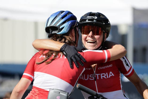 26.08.2026, Daolasa di Commezzadura, Val di Sole Bikeland, 2026 UCI MTB World Championship, WM, Weltmeisterschaft Women Elite s E-MTB XC (E-MTB Cross Country) Tamara Wiedmann 6 (AUT) 3rd place and bronze medal congratulatingAnna Spielmann 1 (AUT) 1st place, World Champion and gold medal Daolasa di Commezzadura Val di Sole Bikeland Trento Italy *** August 26, 2026, Daolasa di Commezzadura, Val di Sole Bikeland, 2026 UCI MTB World Championships, Women’s Elite E MTB XC (MTB Cross Country): Tamara Wiedmann (6, AUT) – 3rd place and bronze medal; congratulations to Anna Spielmann (1, AUT) – 1st place, World Champion, and gold medal. Daolasa di Commezzadura, Val di Sole Bikeland, Trento, Italy Copyright: xJustPictures.ch FrancescoxMinghettix jp-en-FrMi-MNG_0433