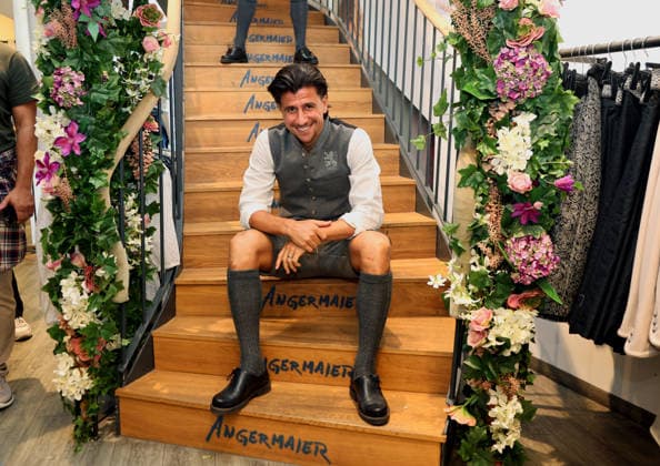 Fussball, Herren, Wiesn Einkleidung, Saison 2026 2027, TSV 1860 München, Trachten Angermaier Tunay Deniz (TSV 1860 München) sitzend auf der Treppe in Tracht, Lederhose