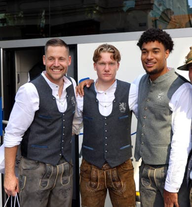 Fussball, Herren, Wiesn Einkleidung, Saison 2026 2027, TSV 1860 München, Trachten Angermaier Vitus Eicher (TSV 1860 München) mit Paul Bachmann (TSV 1860 München) und Arian Ortivero Calderon (TSV 1860 München) (v.l.n.r.) stehend in Tracht, Lederhose