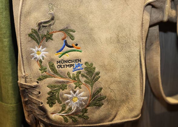 Fussball, Herren, Wiesn Einkleidung, Saison 2026 2027, TSV 1860 München, Trachten Angermaier Hier eine Lederhose mit der Stickerei, München OlympiJA, Olympiabewerbung München, Olympische Sommerspiele, Logo, Wappen