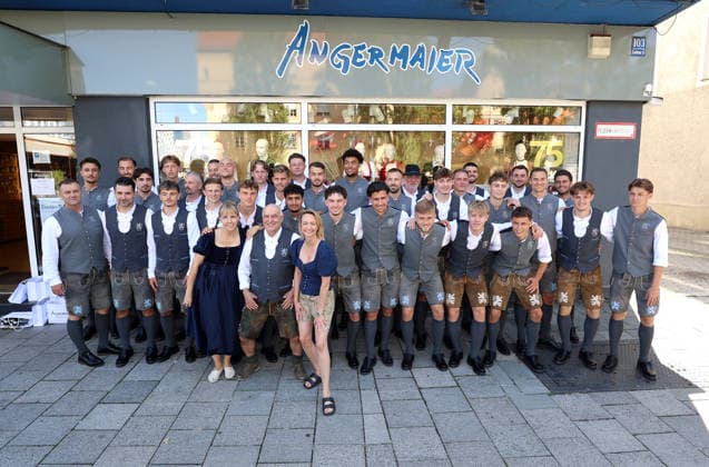 Fussball, Herren, Wiesn Einkleidung, Saison 2026 2027, TSV 1860 München, Trachten Angermaier Die Spieler, Mannschaft des TSV 1860 München zusammen vor dem Geschäft bei Trachten Angermaier, Teamfoto, Mannschaftsfoto, in Tracht, Lederhose mit Axel Munz