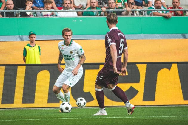 Fussball: Österreich: UEFA Conference League 2026 2027 - Play-offs - Rückspiel, 26.08.2026 - SK Rapid Wien (Österreich) vs. Heart of Midlothian FC (Hearts - Schottland) - Weststadion (Wien, Österreich); Tonni Adamsen (SK Rapid Wien) mit Jamie McCart (Heart of Midlothian FC) Copyright: xLukasxBierederx