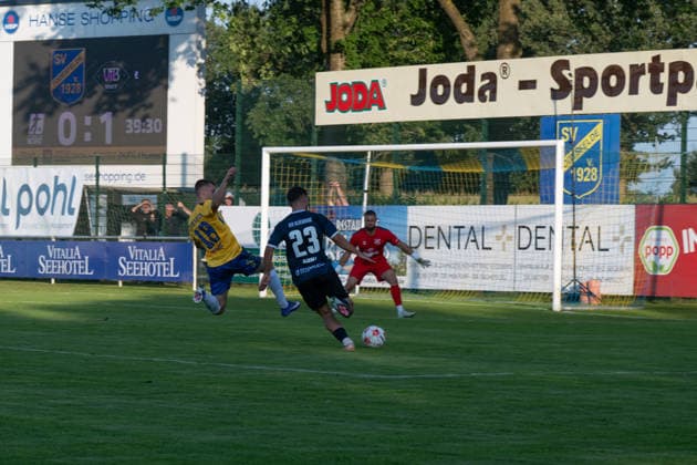 26.08.2026, GER, Fussball, Regionalliga Nord, 5.Spieltag, Saison 2026 2027, Todesfelde, Joda-Sportpark, SV Todesfelde vs VfB Oldenburg, Louis HAJDINAJ ( VfB Oldenburg 23 ) mit dem Schuss zum 0 zu 2 Timon HENK ( SV Todesfelde 18 ) und Fabian LANDVOIGT ( SV Todesfelde 1 ) haben keine Chance Todesfelde Joda-Sportpark Schleswig-Holstein Deutschland Copyright: xnordphotoxGmbHx xRojahnx