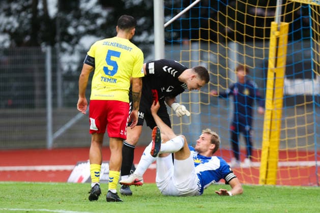 26.08.2026, Fussball, Herren, Regionalliga Nord, 5. Spieltag, SV Atlas Delmenhorst - BSV Kickers Emden, Torwart Damian Schobert (1 SV Atlas Delmenhorst) prallt mit Peer Mahncke (blau 5 BSV Kickers Emden) aneinander