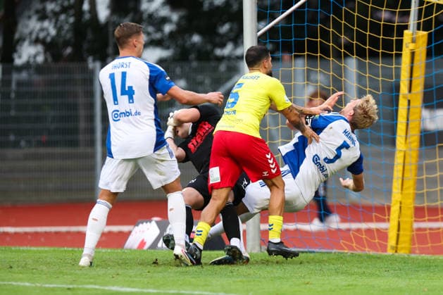 26.08.2026, Fussball, Herren, Regionalliga Nord, 5. Spieltag, SV Atlas Delmenhorst - BSV Kickers Emden, Torwart Damian Schobert (1 SV Atlas Delmenhorst) prallt mit Peer Mahncke (blau 5 BSV Kickers Emden) aneinander