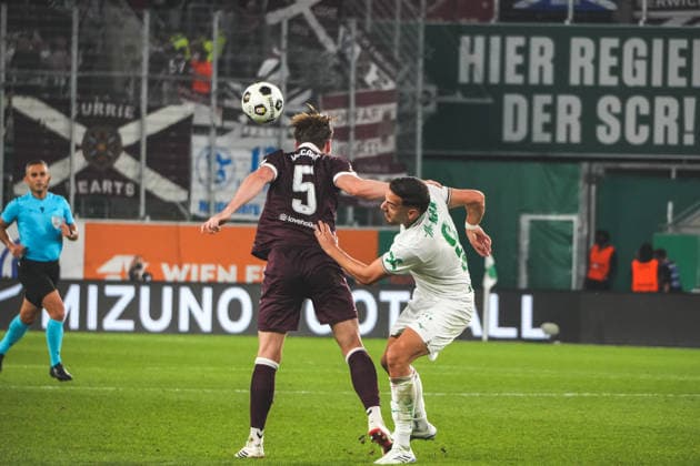 Fussball: Österreich: UEFA Conference League 2026 2027 - Play-offs - Rückspiel, 26.08.2026 - SK Rapid Wien (Österreich) vs. Heart of Midlothian FC (Hearts - Schottland) - Weststadion (Wien, Österreich); Jamie McCart (Heart of Midlothian FC) mit Ercan Kara (SK Rapid Wien) Copyright: xLukasxBierederx