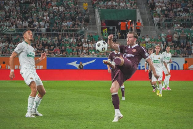 Fussball: Österreich: UEFA Conference League 2026 2027 - Play-offs - Rückspiel, 26.08.2026 - SK Rapid Wien (Österreich) vs. Heart of Midlothian FC (Hearts - Schottland) - Weststadion (Wien, Österreich); Jamie McCart (Heart of Midlothian FC) mit Ercan Kara (SK Rapid Wien) Copyright: xLukasxBierederx