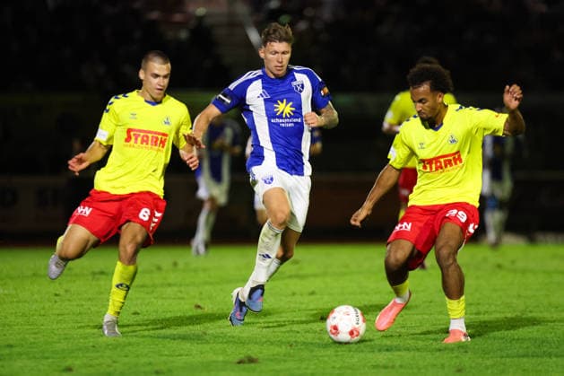26.08.2026, Fussball, Herren, Regionalliga Nord, 5. Spieltag, SV Atlas Delmenhorst - BSV Kickers Emden, Luc Ihorst (blau 14 BSV Kickers Emden) im Zweikampf mit Yegor Melenivskyi (6 SV Atlas Delmenhorst) und Torwart Kilian Sanden (26 SV Atlas Delmenhorst)