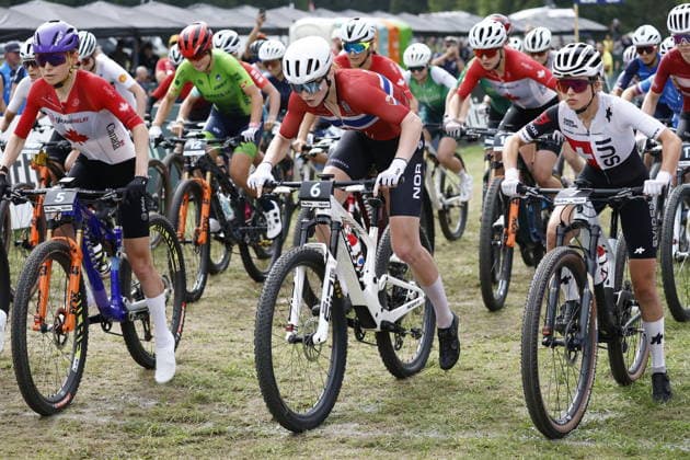 27.08.2026, Daolasa di Commezzadura, Val di Sole Bikeland, 2026 UCI MTB World Championship, WM, Weltmeisterschaft Women U23 s XCC (cross country short track) Elina Benoit 7 (SUI), Lisa Kristine Jorde 6 (NOR), Ella MacPhee 5 (CAN) at the green lights Daolasa di Commezzadura Val di Sole Bikeland Trento Italy Copyright: xJustPictures.ch FrancescoxMinghettix jp-en-FrMi-_NG_0960