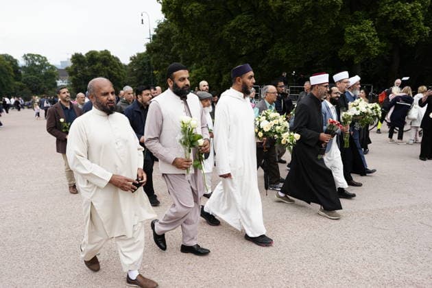 OSLO, NORGE 20260828 Representanter fran olika trossamfund pa väg att lämna blommor framför Kungliga slottet i Oslo efter beskedet att Norges Kung Harald dött. OSLO NORGE x9200x