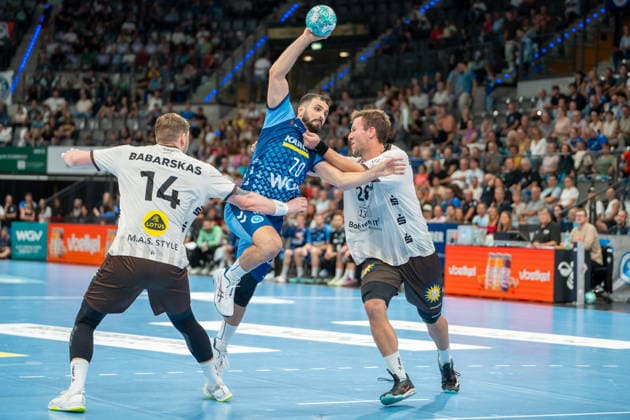 Handball I Herren I Saison 2026-2027 I Bundesliga I 1. Spieltag I TVB Stuttgart - Bergischer HC I 28.08.2026 Mohamed Amine Darmoul (70, TVB Stuttgart) im Wurf verteidigt von Gerdas Babarskas (14, Bergischer HC) und Tom Bergner (28, Bergischer HC) Stuttgart Porsche Arena Baden-Württemberg Deutschland Copyright: xLobeca MaxxPetershansx